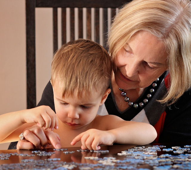 Mujer ayudando a un niño a resolver un puzzle